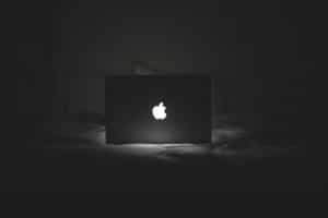 apple computer lighting up a dark bedroom