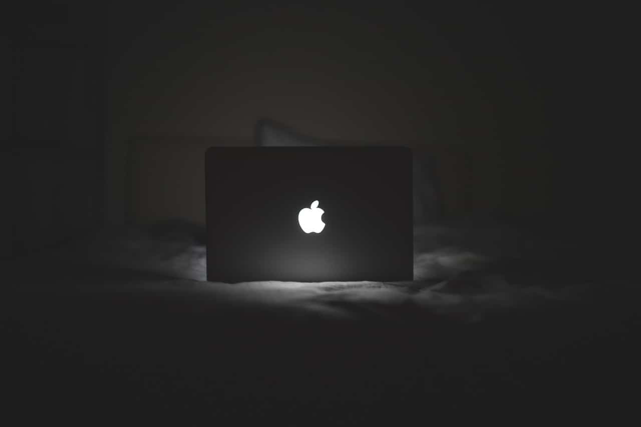 apple computer lighting up a dark bedroom